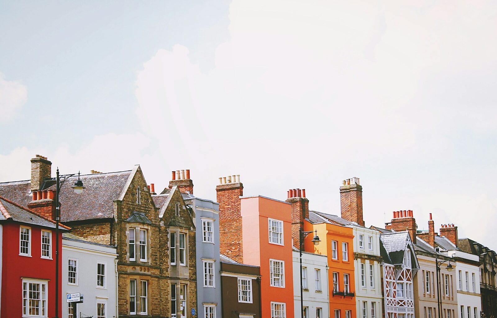 assorted-color concrete houses under white clouds during daytime