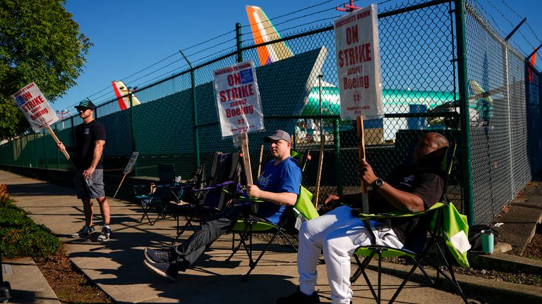 Boeing 737 Max aircrafts are seen behind fences as Boeing employees work the picket line while striking Tuesday, Sept. 24, 2024, next to the company's facilities in Renton, Wash. (AP Photo/Lindsey Wasson)